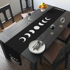 the table is decorated with black and white moon designs on it, along with silverware