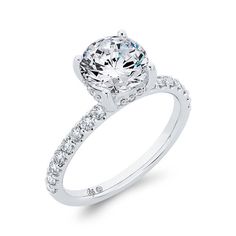 a white gold engagement ring with diamonds on the band and an oval cut center stone