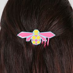 a close up of a person's head with a hair clip in the shape of a bee