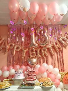 a table topped with lots of balloons and cake