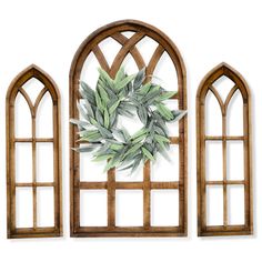 three wooden windows with green leaves on them