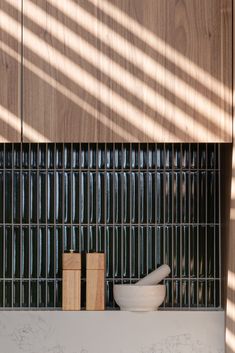 some bowls and wooden blocks are sitting on the counter in front of a wood paneled wall