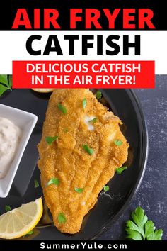 air fryer cat fish on a black plate with lemon wedges and garnish