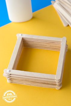 a square wooden frame sitting on top of a yellow table