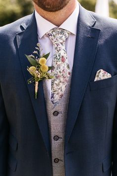 a man wearing a blue suit and flower boutonniere