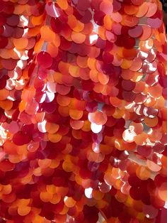 an orange and red dress with lots of circles on the front, as if it were made out of plastic