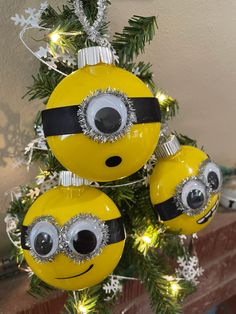 three yellow and black ornaments hanging from a christmas tree