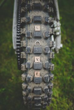 the front tire of a bike with words written on it and some grass in the background