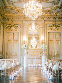 an elegant wedding setup with candles and chandelier in the middle of the room