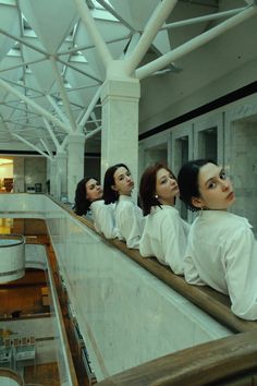 four women are sitting on an escalator and looking up at something in the distance