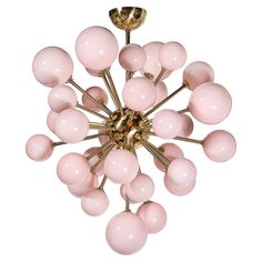 a chandelier with pink glass balls hanging from it's golden metal arms