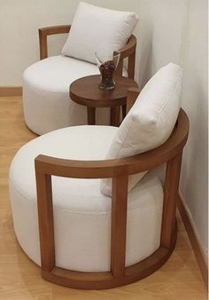 two white chairs sitting next to each other on top of a hard wood flooring