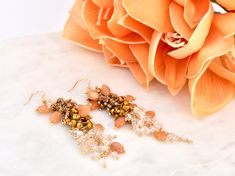 Add a touch of elegance to your look with these stunning fall beaded earrings, perfect for any special occasion or casual event. Featuring a beautiful mix of orange, bronze, and clear crystal beads with gold accents, these earrings capture the essence of autumn. The intricate beaded design offers a unique, eye-catching look for holiday parties, weddings, or bridesmaid jewelry. They are also a beautiful choice for woodland weddings or as boho bridal earrings, adding a natural yet elegant flair. T Luxury Statement Cluster Earrings For Gifts, Luxury Elegant Beaded Earrings For Statement Jewelry, Luxury Gold Bridal Earrings With Dangling Beads, Luxury Orange Earrings For Wedding, Luxury Gold Beaded Earrings For Party, Boho Bridal Earrings, Boho Bridal Jewelry, Fall Bead, Elegant Fall