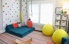 a brightly colored living room with climbing wallpaper and colorful bean bag chairs in the corner