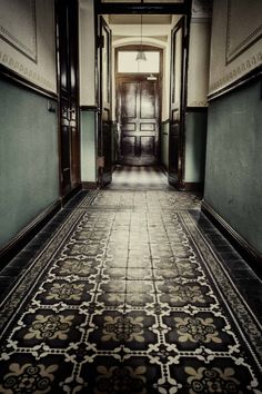 an empty hallway with tiled floors and doors