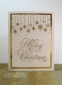 a white card with gold foil on the bottom and merry christmas written across it in black ink