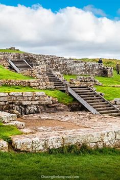 an old stone structure with steps leading up to it and grass growing on the ground