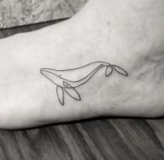 a small whale tattoo on the foot