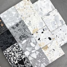 several different colors and shapes of tiles on the ground with black, white, gray, and gold designs