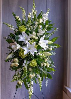 a bouquet of white and green flowers in front of a door