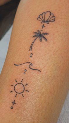 a woman's arm with a tattoo that has a sun and palm tree on it