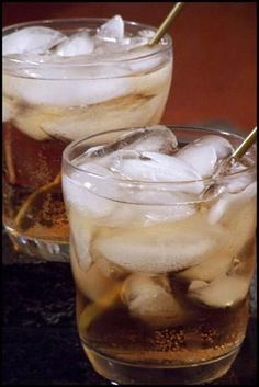 two glasses filled with ice sitting on top of a table