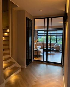 an empty living room with stairs leading up to the second floor and glass sliding doors