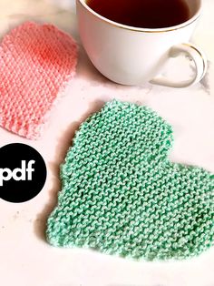 a knitted heart next to a cup of tea