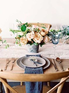 the table is set with flowers and silverware