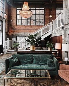 a living room filled with furniture and a large window covered in lots of windows next to a stair case