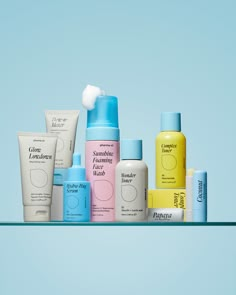 several different types of skin care products are arranged on a shelf against a blue background