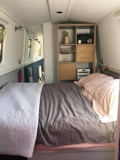 a small bedroom with a bed, dresser and mirror in the corner on the wall