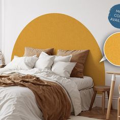 a bedroom with a yellow headboard and white sheets on the bed in front of it