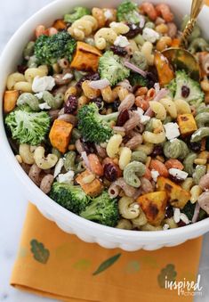 a white bowl filled with broccoli, beans and other vegetables on top of a yellow napkin