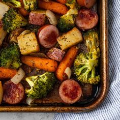 a casserole dish with sausage, broccoli and potatoes