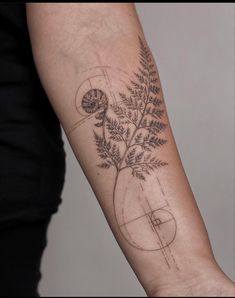 a woman's arm with a plant in a vase tattoo on the left forearm