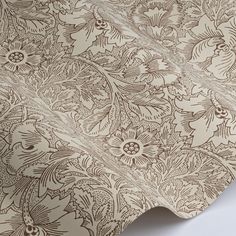 an intricately designed wallpaper with flowers and leaves in brown on white background, close up