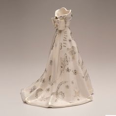 a white porcelain figurine wearing a long dress