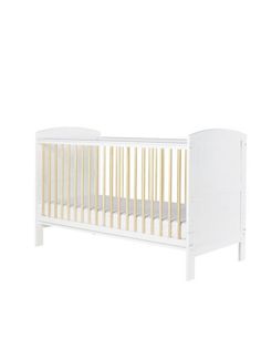 a white crib with wooden slats on the bottom and sides, against a white background