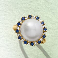 Ross-Simons - 12.5-13mm Cultured Button Pearl, .60ct t. w. Sapphire Ring, Diamond Accents. Size 5. This gorgeous ring makes a luxury statement as it flaunts a gleaming 12.5-13mm cultured freshwater button pearl from a halo of .60 ct. t. w. sapphires and diamond accents. Set in 14kt yellow gold. Sapphire and white pearl ring. Pearl birthstones are the perfect gift for June birthdays. Luxury Pearl Ring With Center Stone, Aaa Quality Round Diamond Ring, Luxury Round Pearl Ring With Halo, Luxury Round Pearl Ring With Halo Setting, Elegant Blue Pearl Ring, Elegant Blue Pearl Ring For Formal Occasions, White Pearl Ring, Pearl Birthstone, Ring Pearl