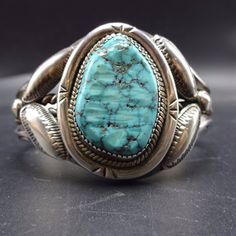 "VINTAGE NAVAJO BRACELET DESCRIPTION: This impressive cuff features a gorgeous specimen of Carico Lake turquoise. The gemstone is secure in sawtooth bezel, on a foundation of heavy gauge vintage sterling silver. A heavy braided band of sterling silver bisects the hand-stamped carinated cuff, and stamped and repousse ovals frame the gemstone. This spectacular bracelet will be a cherished addition to your collection of fine vintage Native American jewelry. MEASUREMENTS: Interior of the cuff measur Classic Handmade Cuff Bracelet Collectible, Vintage Turquoise Cuff Bracelet, Vintage Patina Cuff Bracelet, Vintage Cuff Bracelets For Collectors, Vintage Cuff Bracelets Collectible, Vintage Cuff Bracelet With Patina, Collectible Vintage Cuff Bracelet, Vintage Native American Jewelry, Navajo Bracelet