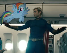 a man in a blue outfit holding up a paper cutout of a rainbow dash