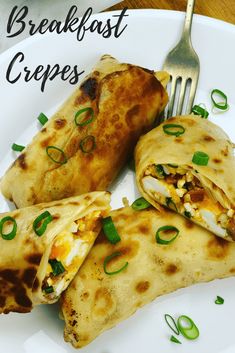 a white plate topped with two burritos and a fork