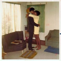 two people standing in a living room hugging each other