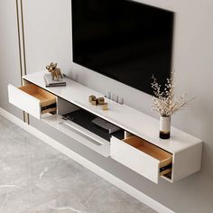 a white entertainment center with two drawers and a flat screen tv mounted on the wall