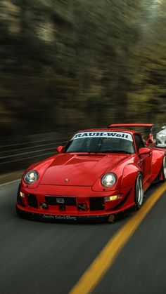 a red sports car driving down the road