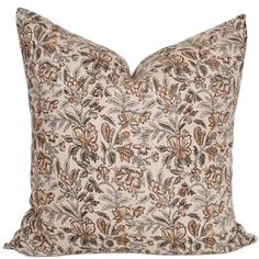 a brown and white floral pillow on a white background