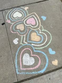 the sidewalk has hearts drawn on it and is painted with pastel pencils in different colors