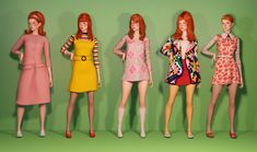 five dolls are posed in front of a green background