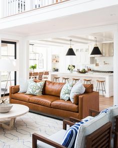 a living room filled with furniture next to a stair case in a white house on instagram